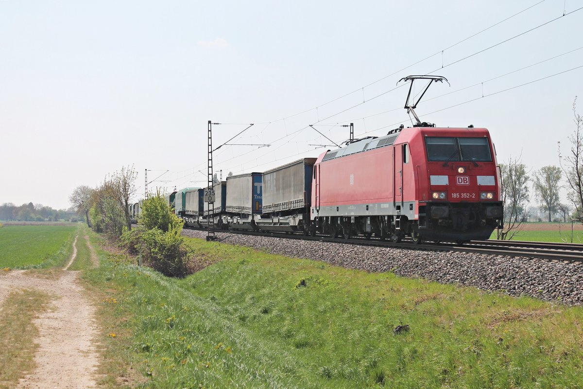 Am Mittag des 11.04.2017 bespannte die 185 352-2 den  Lannutti -KLV (Torino Orbassano - Charleroi Dry Port) ab der Schweizer Grenze, als sie bei Hügelheim über die KBS 703 durchs Rheintal in Richtung Freiburg (Breisgau).