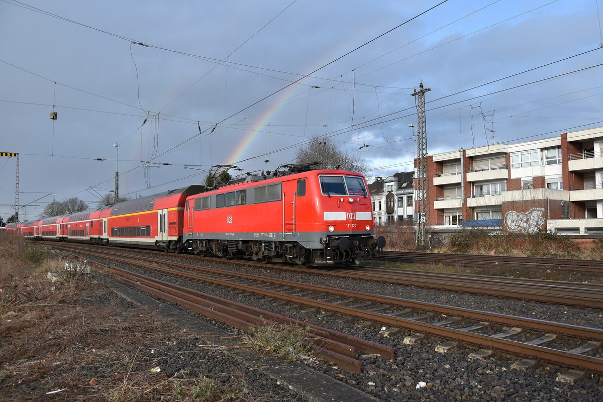 Am Montag den 12. März 2018 wechselte oft in rascher Folge Regen und Sonnenschein und so kam auch diese Aufnahme zustande als die 111 127 mit ihrem RE4 Rheydt Hbf gen Aachen Hbf am späteren Nachmittag verließ. 