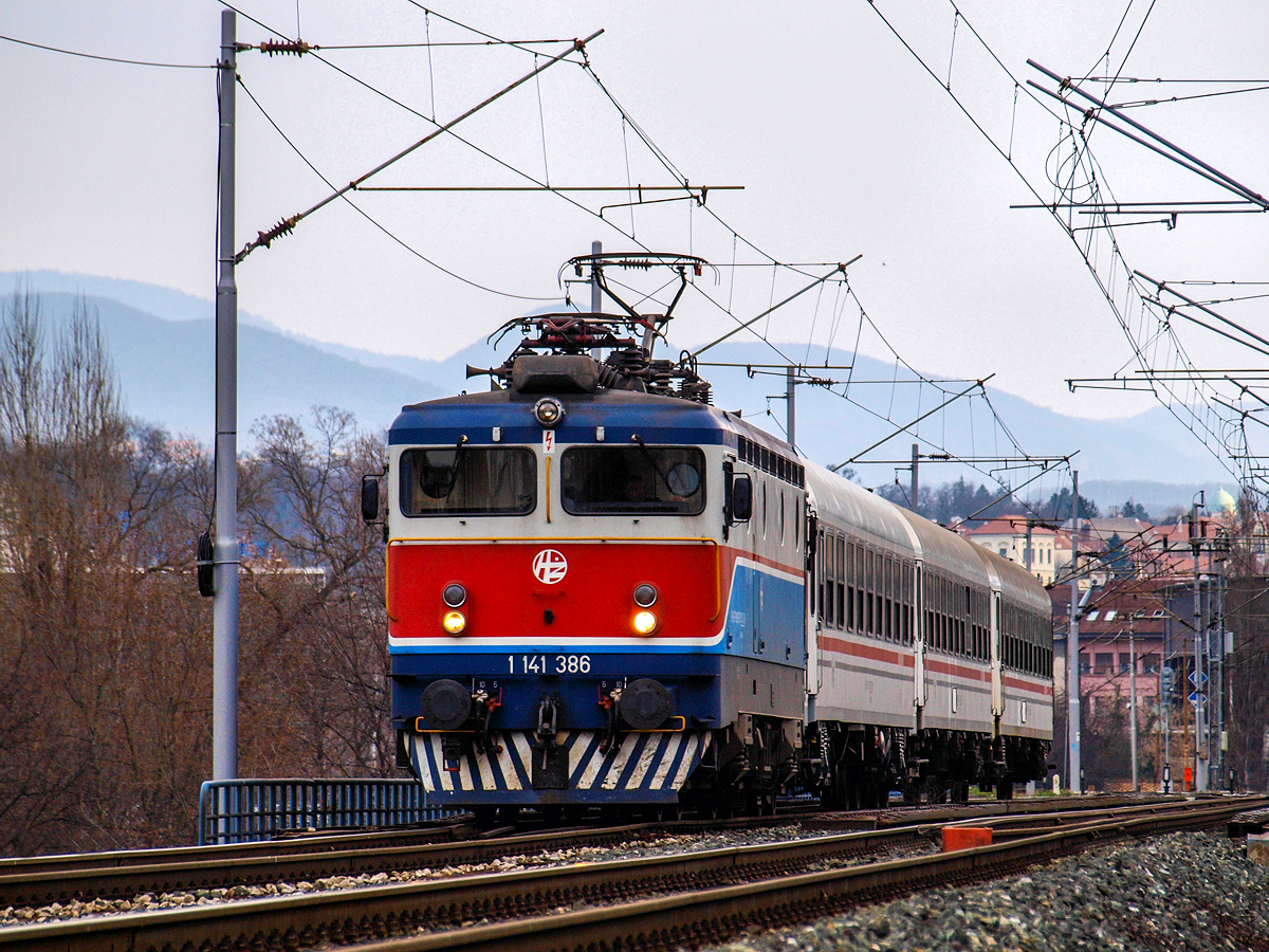 Am Morgen des 13.03.2015. verlässt die 1141 386 an der Spitze des Personenzuges 4000 den Zagreber Hauptbahnhof in Richtung Süden, ganz am Anfang der über 200 Kilometer langen Fahrt nach Rijeka. Die drei Wagen am Haken sind mehr als genug für die an den zahlreichen Zwischenhalten ein- und aussteigenden Fahrgäste, sowie die sehr wenigen welche sich für eine fünfstündige Zugfahrt von der kroatischen Hauptstadt bis an die Adria entschieden haben.