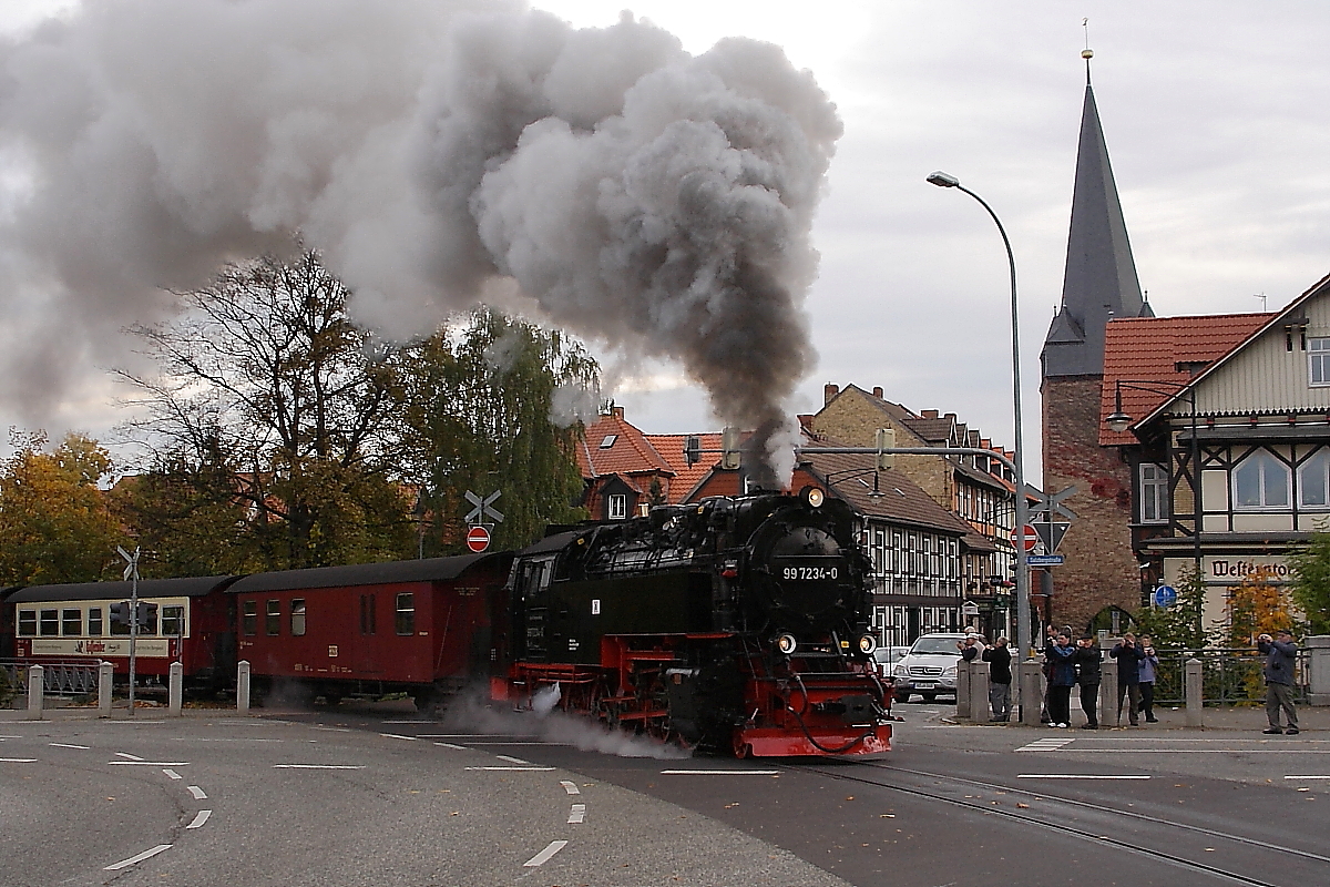 Am Morgen des 20.10.2013 stampft 99 7234 mit P8931, dem ersten Zug des Tages in Richtung Brocken, mit mächtiger Dampffahne über die Westerntor-Straßenkreuzung in Wernigerode.