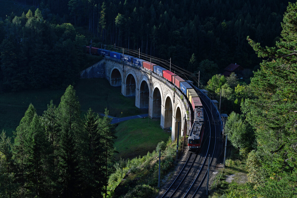 Am Morgen des 26. September 2021 erreichten die ersten Sonnenstrahlen das Adlitzgraben-Viadukt, als es die 1144.209 und eine Schwestermaschine mit einem schweren Containerzug talwärts fahrend passierten. 