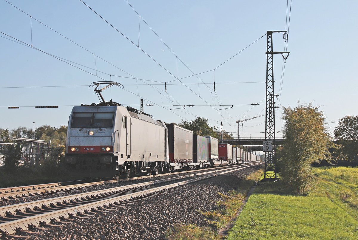 Am Nachmittag des 16.10.2019 fuhr Maquarie/XRAIL/TXL 186 906 mit dem  WETRON/Jan de Rijk -KLV DGS 41032 (Melzo Scalo - Köln Eifeltor) beim Haltepunkt von Auggen durchs Markgräflerland in Richtung Freiburg (Breisgau).