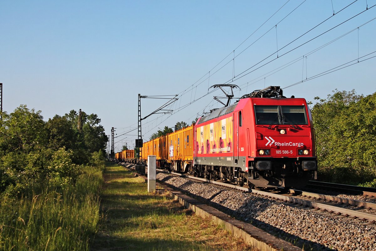 Am Nachmittag des 23.05.2019 fuhr ATLU/RHC 2054 (185 586-5  Heizprofi  mit dem  Bauer -Containerzug nach Basel beim Haltepunkt von Buggingen über die KBS 703 durchs Rheintal in Richtung Zielbahnhof, welcher nur noch wenige Kilometer entfernt ist.