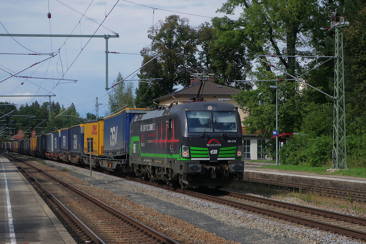 Am Nachmittag des 3. Septembers 2020, einem Donnerstag, durchfährt Vectron 193 275 mit einem langen Zug des kombinierten Ladungsverkehrs den Bahnhof von Aßling an der Hauptstrecke von München nach Rosenheim. Der Vectron gehört ELL und ist vermietet an TXL, auf der Seite trägt er die Aufschrift  We Love To Connect .