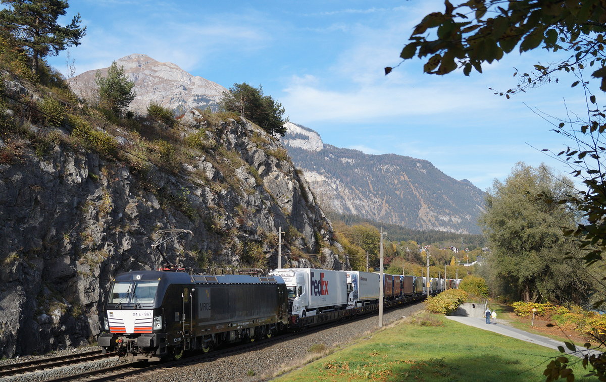 Am österreichischen Nationalfeiertag waren die Züge der Rollenden Landstraße sehr gut ausgelastet. Bei Wiesing schiebt der Vectron X4E 867 (193 867) einen solchen Zug mit Ziel Wörgl Terminal durch die bunte Landschaft. 26.10.2018.