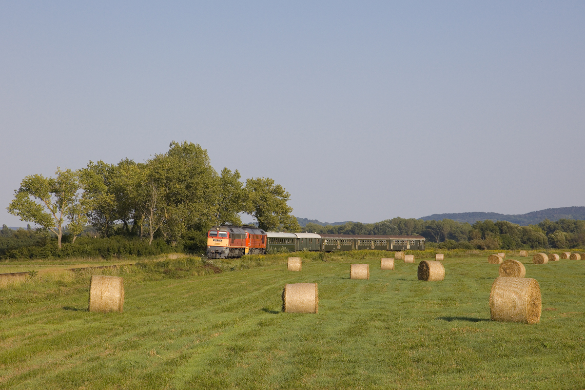 Am Samstag, dem 26. August 2023 war ungeplant sogar eine M62 - Doppeltraktion am Balaton-Nordufer unterwegs. Angeblich hatte die  Retro -Lok M62 187 Probleme mit der Motorkühlung, weswegen man kurzerhand die 628 304 vorgespannt hat. 
Hier ist diese seltene Komposition mit dem Sz 19776 (Balatonfüred - Tapolca) unterwegs und wird in wenigen Minuten den Zugendbahnhof erreicht haben. 