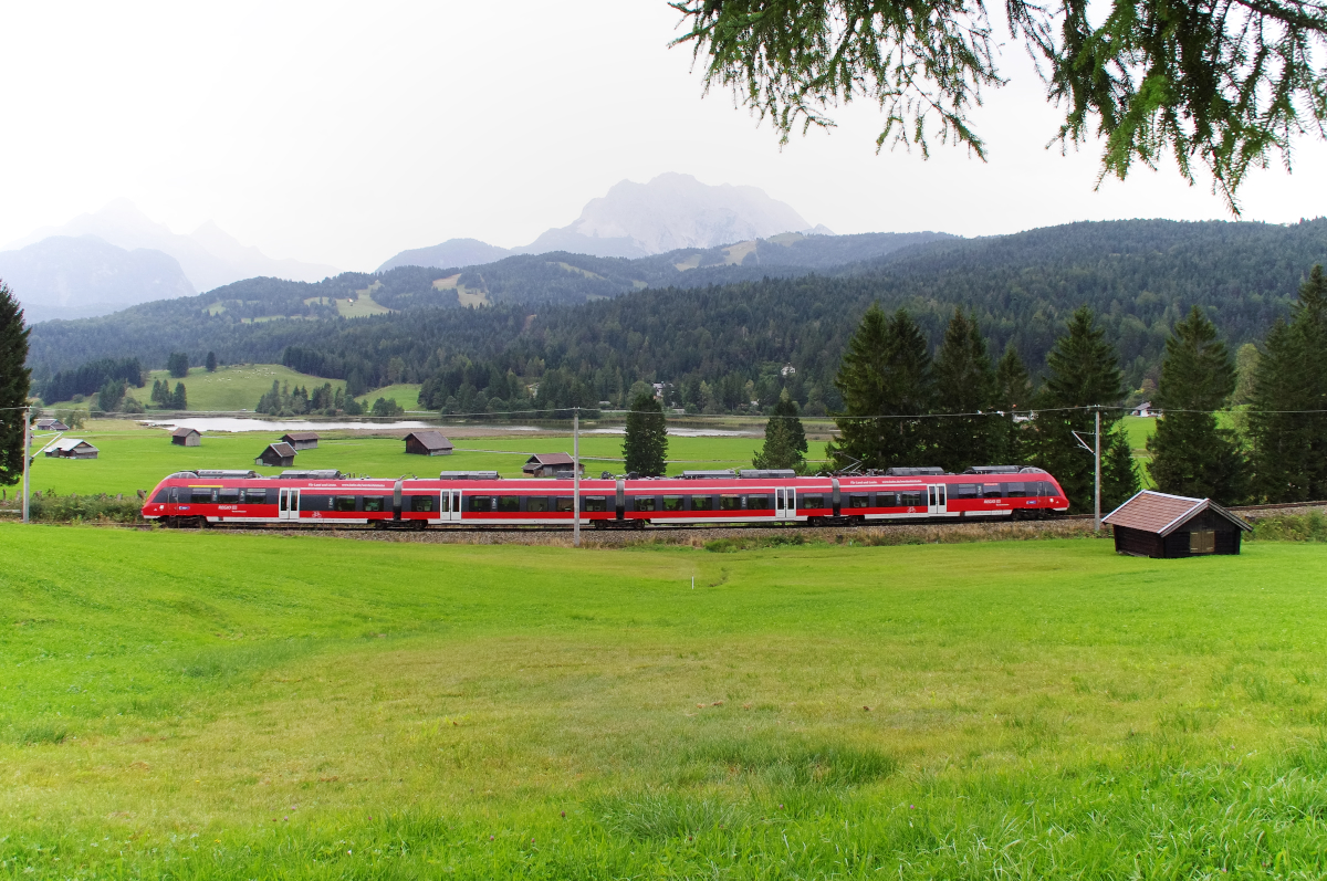 Am Schmalensee mit Blick auf die Zugspitze - Ein Hamsterbäckchen der DB Regio Werdenfelsbahn ist als RB München - Mittenwald unterwegs und umrundet den Schmalensee. Bis Mittenwald sind es nur noch wenige Kilometer und es geht nur noch bergab. Bahnstrecke 5504 München - Mittenwald Grenze am 15.09.2016