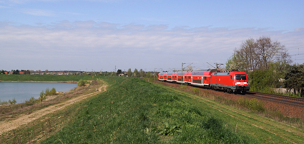 Am sonnigen 11.04.2014 verkehrte auf der Saxonia Linie (RE 50) auch eine Doppelstockgarnitur mit Dresdener S Bahn Taurus. Hier zu sehen in Zeithain am örtlichen 'Kiesteich'.