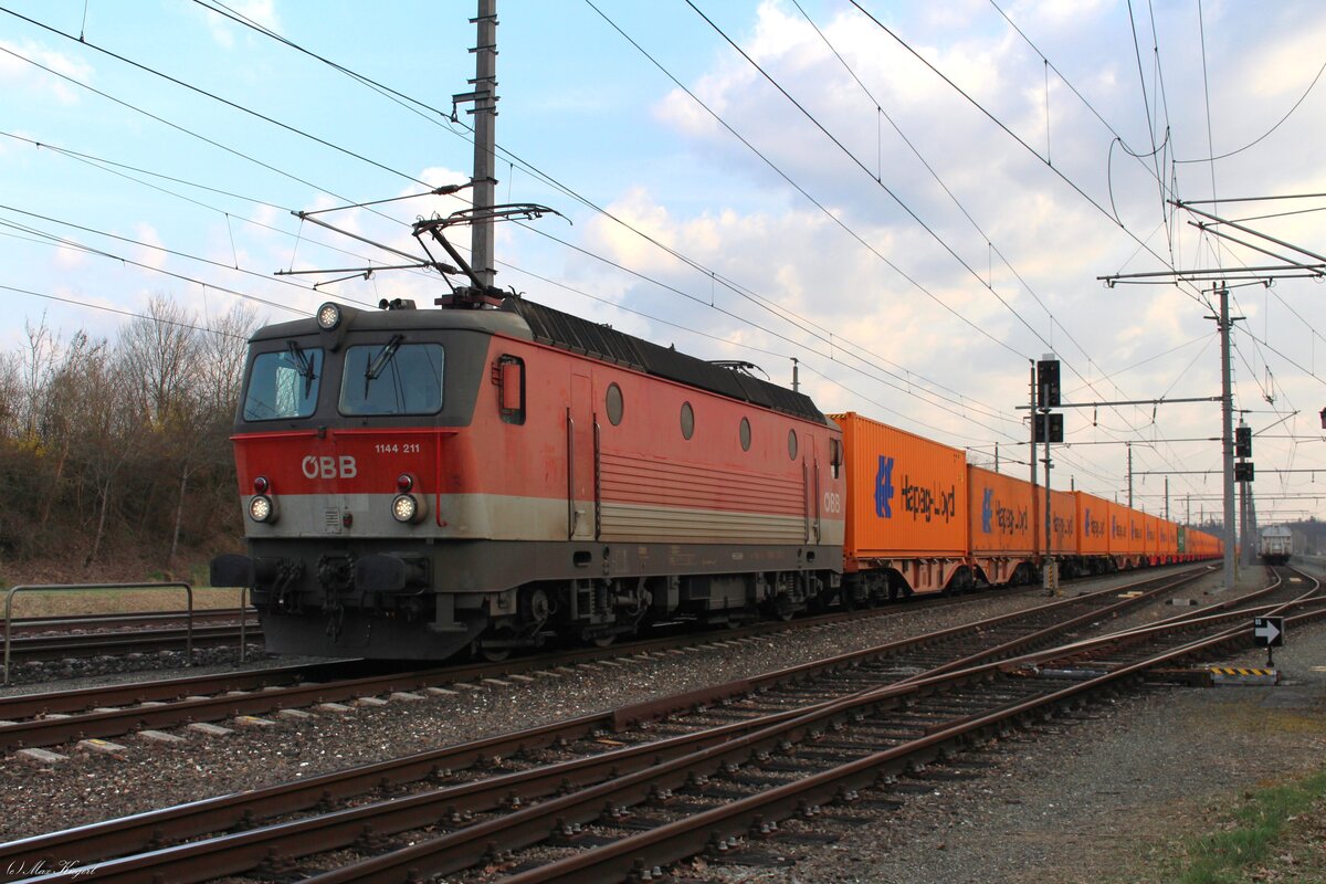 Am späten Nachmittag des 18.3.2026 steht die 1144 211 mit einem Containerzug im Bahnhof Kalsdorf Terminal und wartet auf die Abfahrt nach Enns.
Der ca 500m lange Ganzzug hatte bis auf zwei Container nur orange Hapag-Lloyd Container geladen.