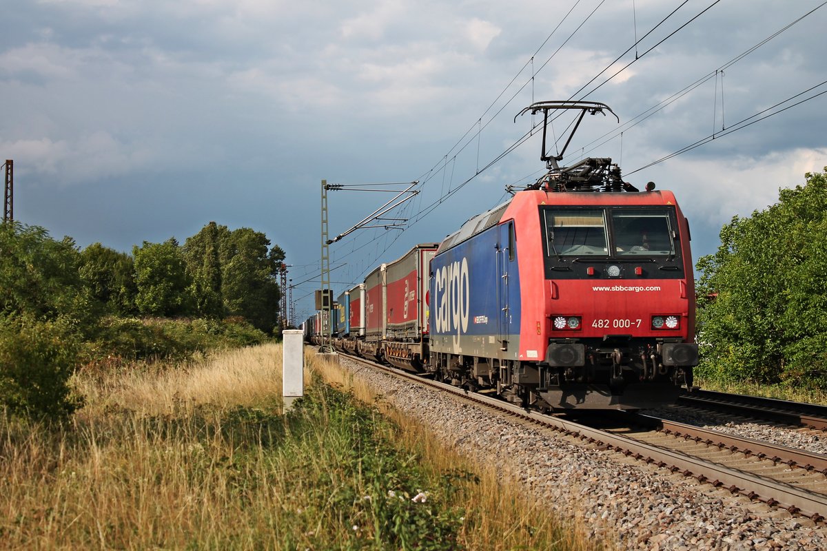 Am späten Nachmittag des 20.07.2017 fuhr Re 482 000-7  Köln  mit einem  arcese -KLV bei Buggingen in Richtung Schweizter Grenze. Am linken Bildrand ist ein alter Oberleitungsmast vom ehemaligen Güterbahnhof Buggingen zu erkennen, der bis heute noch existiert.