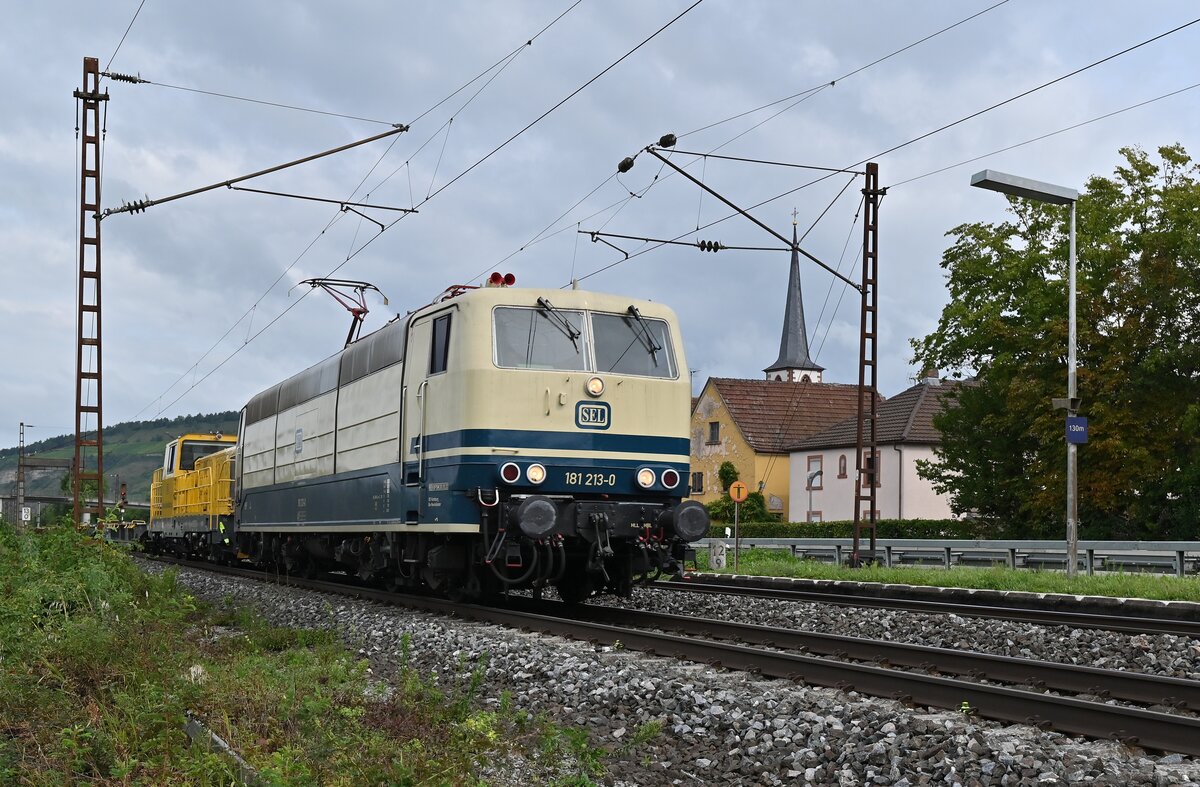 Am späten Vormittag kommt 181 213 mit einem Bauzug von DB am Haken durch Thüngersheim am dienstag den 31.8.2021 gen Würzburg gefahren.