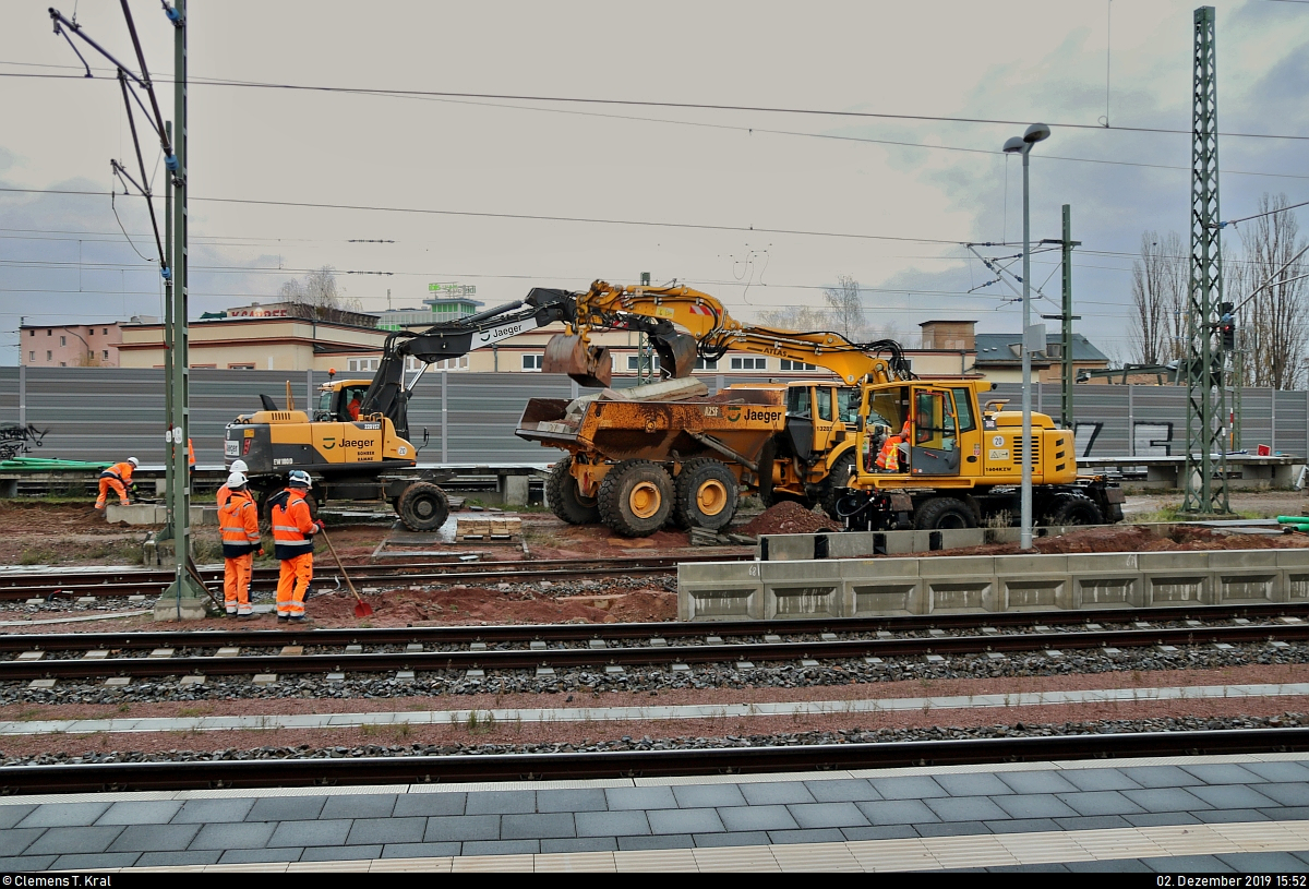Am Tag der offiziellen Inbetriebnahme der Westseite (Gleise 4–7) in Halle(Saale)Hbf wurde mit dem Rückbau des Interimsbahnsteigs Halle(Saale)Hbf Gl. 13a auf der Ostumfahrung für den Güterverkehr (6349) begonnen. Nach vier Jahren stehen zumindest wieder 10 statt bisher 7 bzw. 8 von 13 Gleisen zur Verfügung, sodass diese im November 2016 entstandene Behelfslösung entbehrlich wird.
Hierfür rollten (Zweiwege-)Bagger und ein Kipplader von Jaeger Bernburg (Jaeger Ausbau Beteiligung GmbH + Co KG) an, um die Platten von Bahnsteig und dessen Zugang zu demontieren.
Damit fällt eine meinerseits beliebte Fotostelle nun wieder weg.

(Bild 2)
[2.12.2019 | 15:52 Uhr]