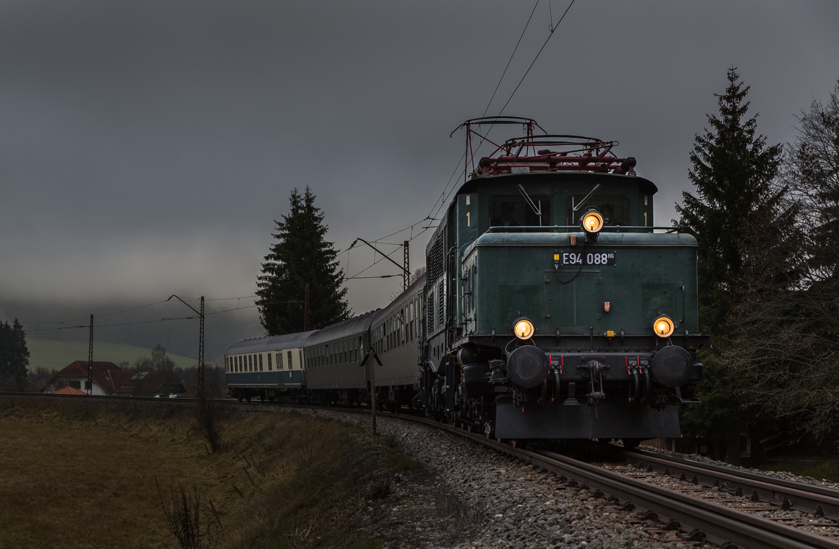 Am Wochenende des 5/6. Dezember 2014 war E94 088 der GES Stuttgart, anlässlich von Nikolausfahrten auf der Höllentalbahn und der Dreiseenbahn unterwegs. 
Wer im Lexikon eine Definition von Sch...wetter sucht, findet bestimmt genau dass, wie es an diesem Wochenende im Schwarzwald war: Schneeregen, Nebel und 0 bis 1 Grad. 
Foto: Titisee, 6.12.14 