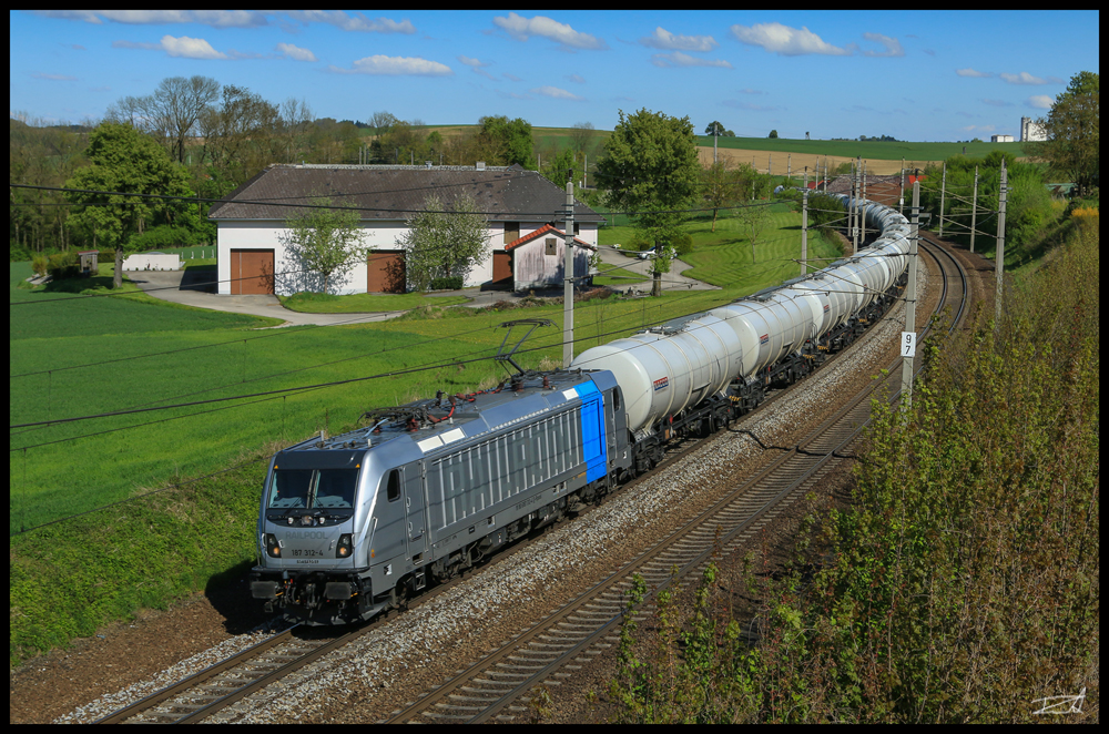 An einem der ersten wirklich schönen Tage im Jahr 2017 zieht die Railpool 187.312 einen Ganzzug gebildet aus Kesselwagen auf der Passauerbahn in Richtung Deutschland. Haiding 02.05.2017