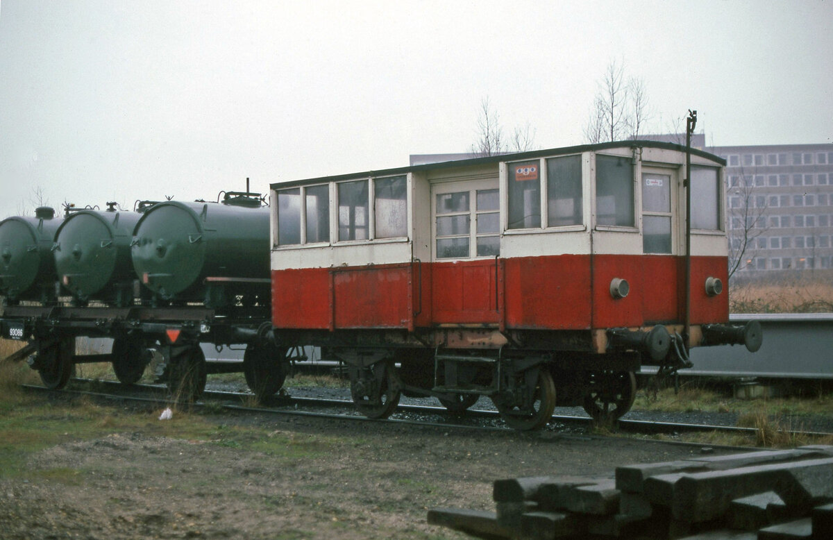 An einem sehr trüben Dezembertag konnte ich die Dieselmechanische Rangierlok M2 der SHM fotografieren. Die Lok war ein Eigenbau des Vorbesitzers (Gasfabriek Haarlem) und erhielt  den Namen  sytje . Angeschnitten ist noch Containerwagen nr 101 sichtbar. Beide Fahrzeuge blieben nicht erhalten. Hoorn, 23.12.1979. Scan (Bild 155, Kodachrome64).