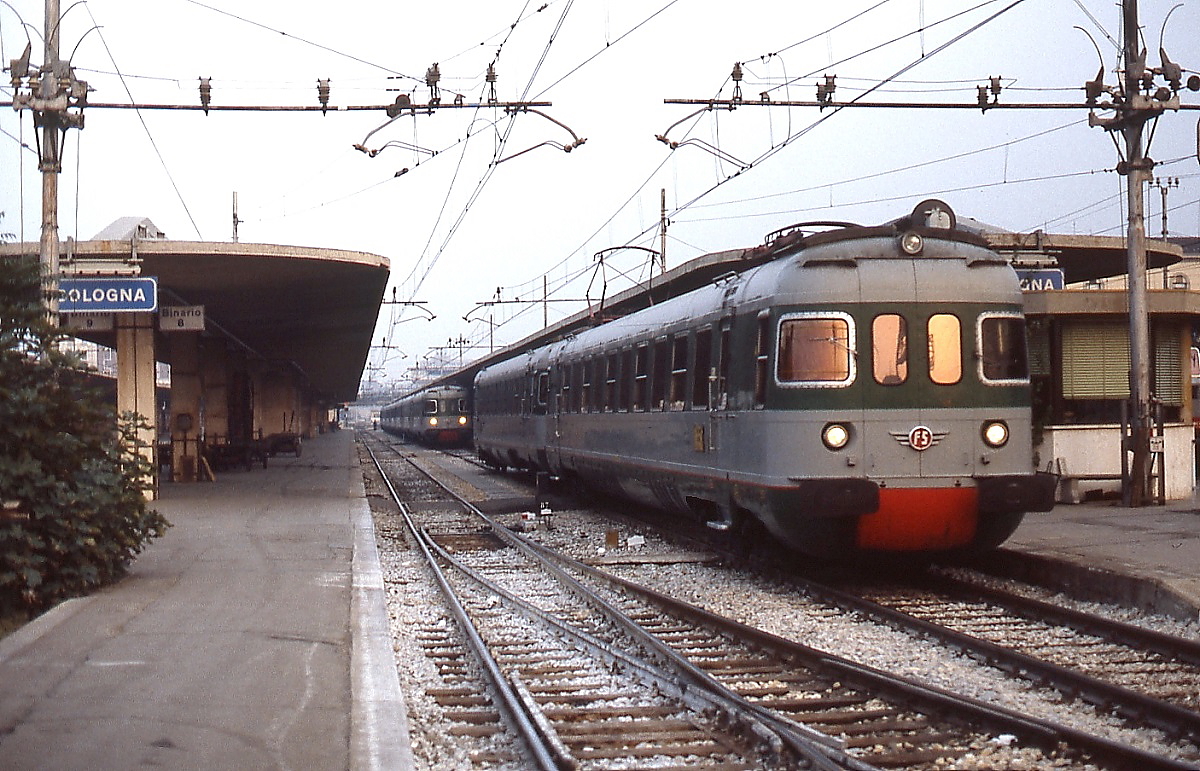 An einem Septemberabend 1986 verlässt ein ALe 601 den Bahnhof Bologna. Der Triebwagen war mit weiteren, im Hintergrund sichtbaren, ALe 601 im Zugverband nach Bologna gekommen. Hier wurden sie getrennt und verkehrten weiter zu ihren verschiedenen Zielbahnhöfen. Auch wenn man es den Triebwagen nicht unbedingt ansieht, sie wurden für den Schnellzugdienst konstruiert und erreichten eine Höchstgeschwindigkeit von 180 bzw. 200 km/h.