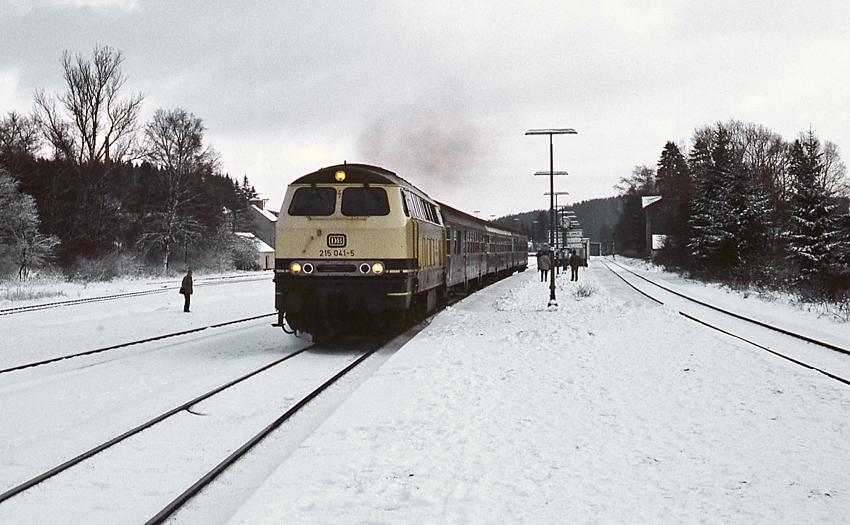 An einem Wintertag Anfang der 1990er Jahre verlässt 215 041-5 mit einem Nahverkehrszug Blankenheim (Wald). So wie jetzt die LINT 81 dominierte damals die Baureihe 215 den Verkehr auf der Eifelbahn.