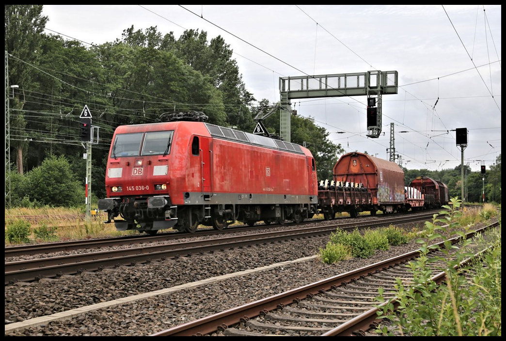 An der Einfahrt in den Bahnhof Hasbergen ist hier die DB 145036-0 mit einem gemischten Güterzug am 1.7.2022 in Richtung Osnabrück unterwegs.