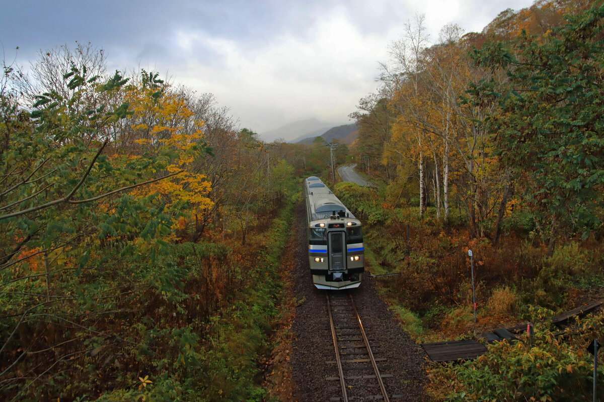 An der einstigen Hauptstrecke von Hakodate nach Sapporo: Am Morgen früh kommt ein dreiteiliger Dieselzug vom Hochplateau von Kutchan herunter. Er wird nach Erreichen der Küste an einen elektrischen S-Bahnzug gekuppelt für die Weiterfahrt nach Sapporo. Bild: Zug KIHA 201-103 bei Shikaribetsu, 29.Oktober 2022 