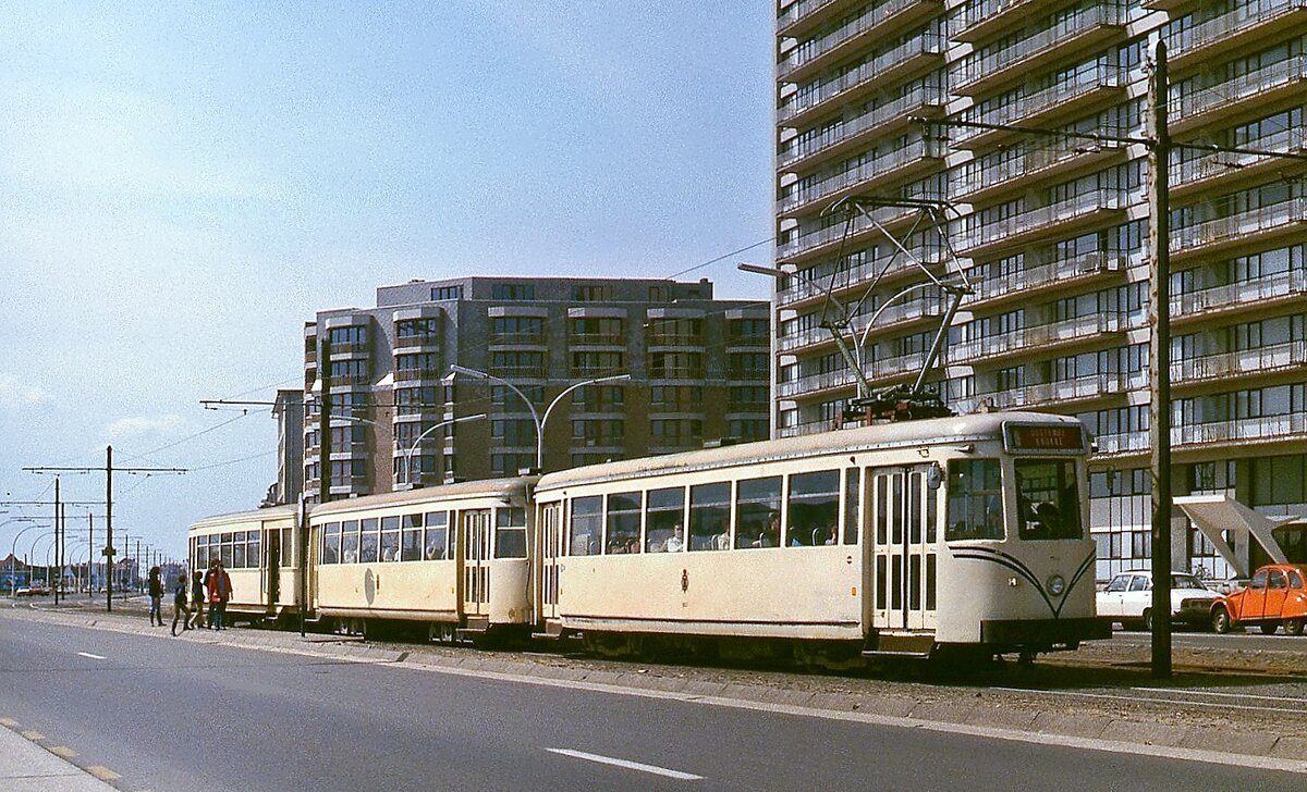 An einer Haltestelle am Stadtrand von Oostende legt ein Dreiwagenzug der  kusttram  im April 1979 auf dem Weg nach De Panne einen Zwischenhalt ein. Wie dieser waren auch die anderen Züge stets gut gefüllt.