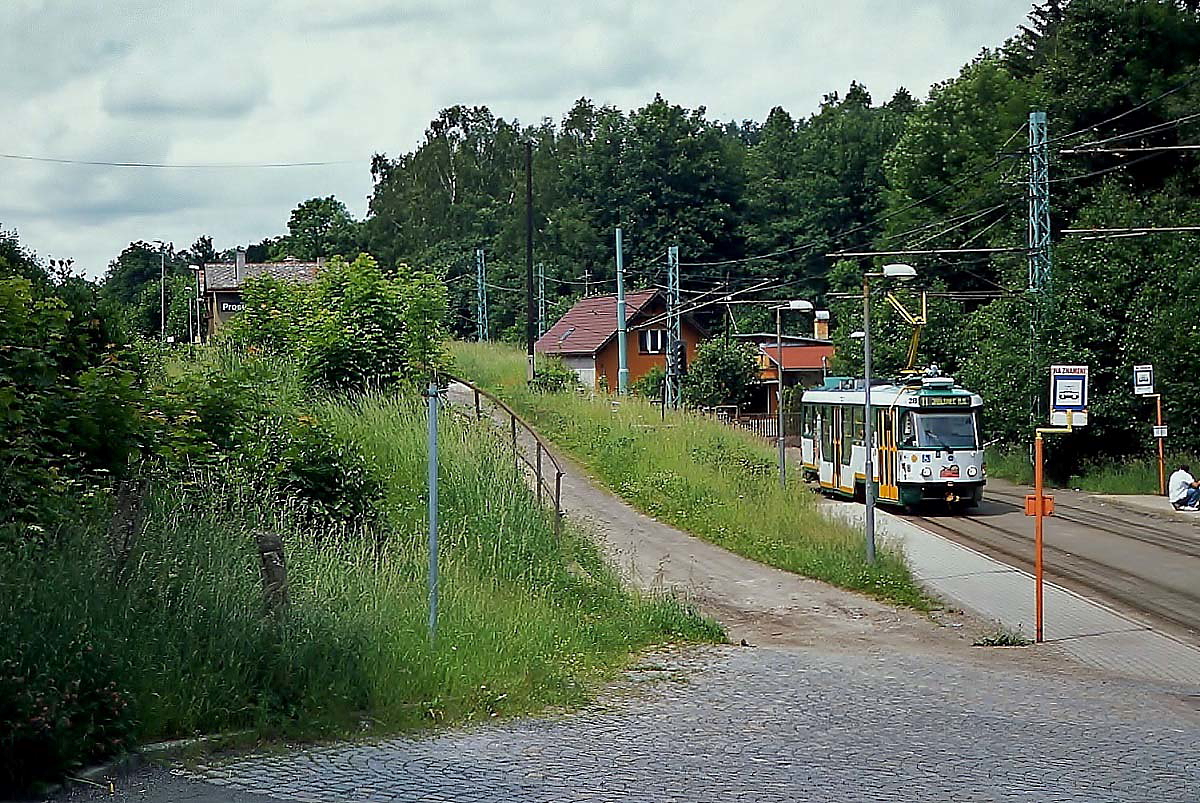 An der Haltestelle Prosec Posta haben die Anwohner die Möglichkeit, entweder mit der Überlandstraßenbahn nach Liberec bzw. Jablonec zu fahren oder in den Zug einzusteigen. Links im Hintergrund ist der CSD-Bahnhof Prosec nad Libou der Bahnstrecke von Liberec über Jablonec nach Tanvald zu sehen. Tw 28 ist am 15.06.2013 nach Jablonec unterwegs.