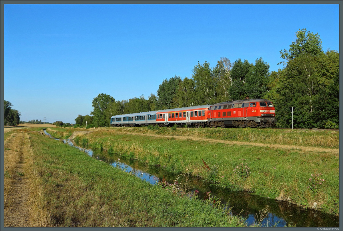 An der Holtemme entlang rollt 218 495-0 der DB Regio mit ihren 3 n-Wagen als RE 21-Ersatzzug Richtung Halberstadt. (bei Wehrstedt, 24.08.2022)