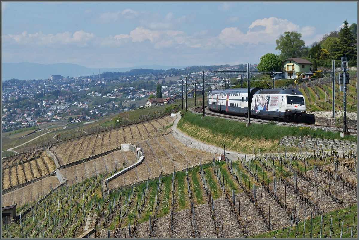 An praktisch der selben Stelle, nur aus einem andern Winkel fotografiert: Die SBB Re 460 041-7  redcross  dem IR 2529 von Genève nach Luzern beim Einfahrsignal von Grandvaux. 
23. April 2014