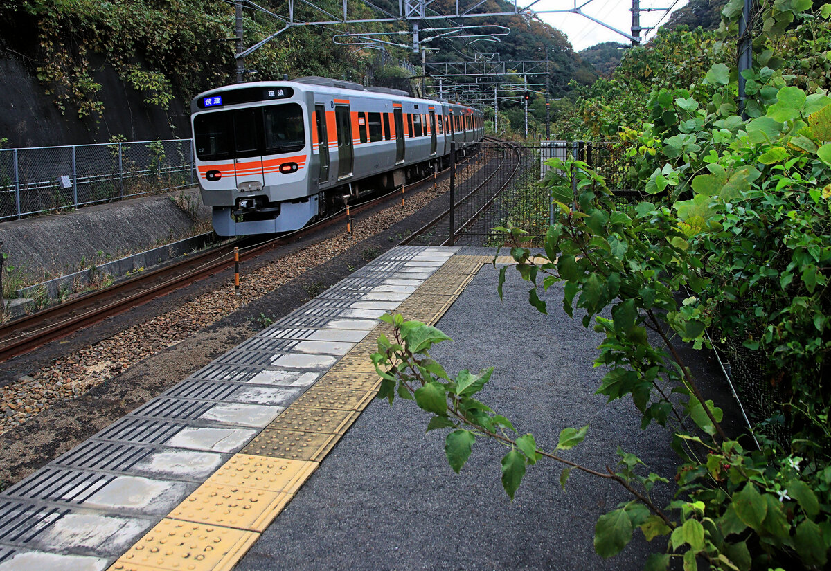 An der westlichen Chûô-Linie aufs Hochplateau von Matsumoto hinauf. Chûô heisst  zentral  und verweist auf die alte Hauptstrasse zwischen Ost- und Westjapan durchs zentrale Bergland anstatt der Küste entlang. Hier fährt ein ganz neuer Regionalzug Serie 315 (Nr. 7) durch das üppige Unkraut der Station Kokokei. 6.November 2023  
