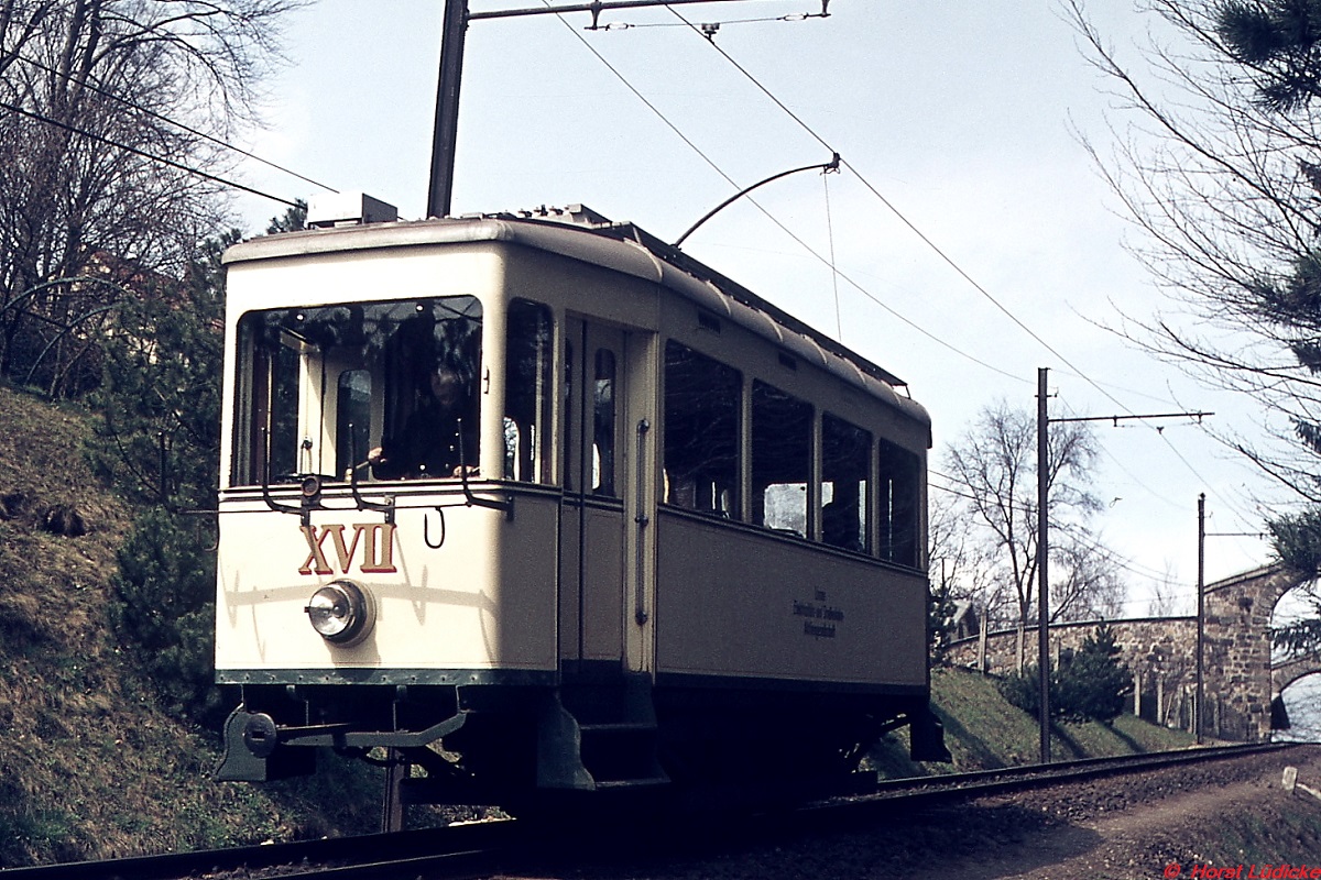 Anfang April 1975 hat Tw XVII der Pöstlingbergbahn gerade den Bergbahnhof verlassen. Mit einer Steigung von fast durchgehend 10,5 % gehört die Bahn zu den steilsten Adhäsionsbahnen der Welt. Damit durchgehende Bahnen aus der Innenstadt verkehren könnne, wurde die Bahn 2008/2009 von den ursprünglichen 1.000 mm auf die 900 mm der Linzer Straßenbahn umgespurt. Gleichzeitig wurden vier moderne Niederflurtriebwagen beschafft.