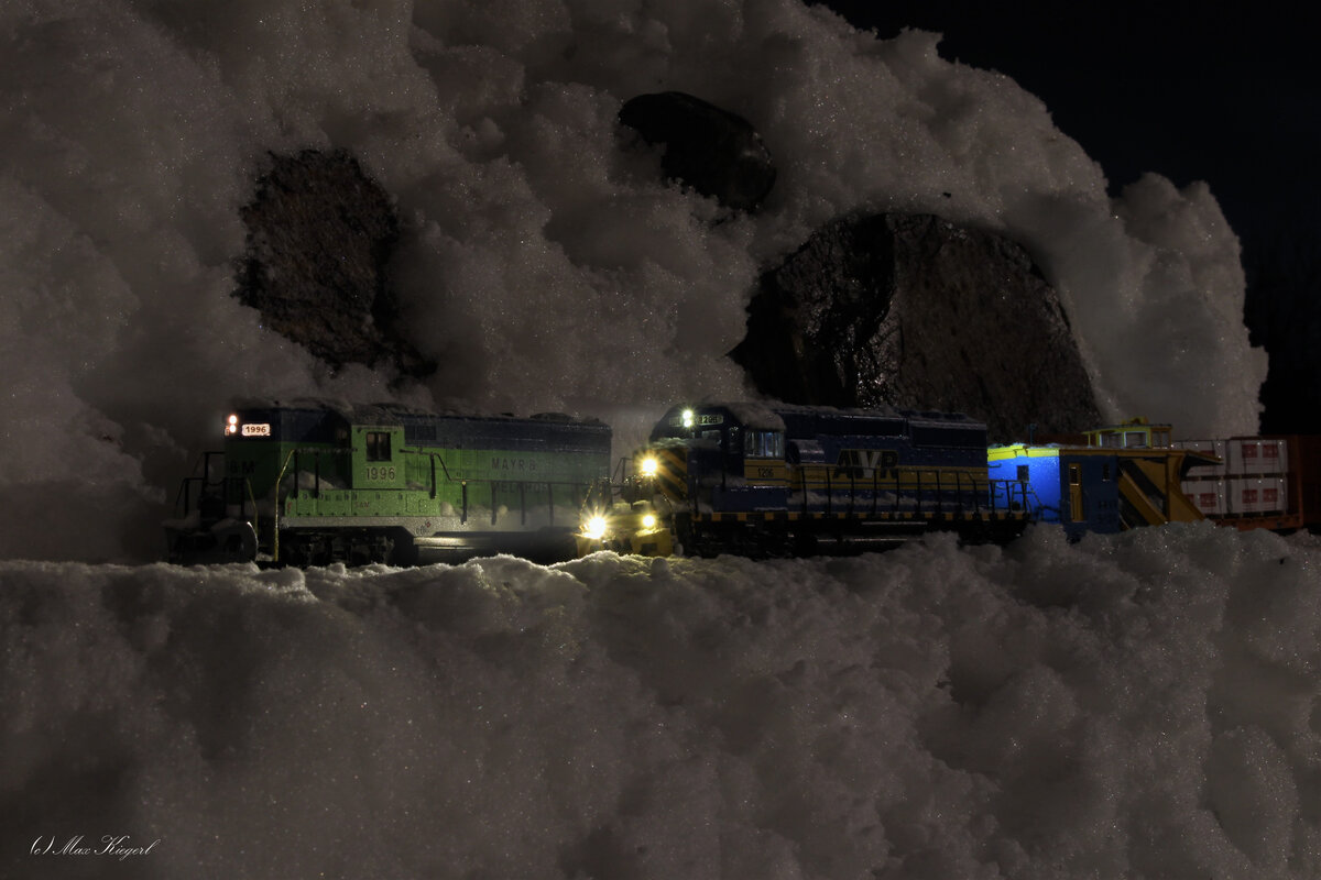 Anfang Dezember 2023 sorgte ein heftiger Blizzard am Lonsperchpass für Chaos und nur durch den Einsatz von Schneepflügen rund um die Uhr konnte der Betrieb aufrecht erhalten werden.
Am Abend des 3.12.2023 kreuzt die talwärts fahrende AWVR SD40-2 #1206 mit einem Russell Snowplow einen bergwärts fahrenden Güterzug der von der Mayr&Melnhof Railroad GP9 #1996  Sam  nachgeschoben wird.