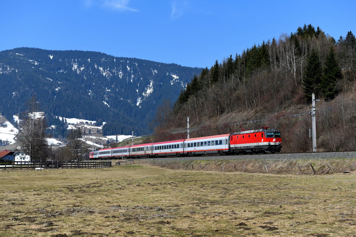 Anfang Februar 2019 verließ die 1144.283 das Werk Linz nach ihrer Teilausbesserung. Zur Freude vieler wurde die Lok auf Initiative engagierter Mitarbeiter des Technischen Service in ihren ursprünglichen Auslieferungszustand Mitte der 1990-er Jahre zurückversetzt. Dabei wurde auf folgendes geachtet: ÖBB-Signet in Form des Pflatsches, große Betriebsnummer in rot im Bereich der Stirnfront und aufgeklebtes  Doppelfabrikschild  am Lokrahmen. Nicht berücksichtigt wurde der umbragraue sogenannte LZB-Streifen unterhalb der Lokdachkante. Am 01. April 2019 war diese schöne Maschine für die Beförderung des IC 515 von Innsbruck nach Graz eingeteilt. Bei Altenmarkt im Pongau konnte ich den innenalpinen Fernzug aufnehmen. In der vorfrühlingshaften, farblich recht eintönigen Landschaft stach die frisch lackierte Lok um so deutlicher hervor. 