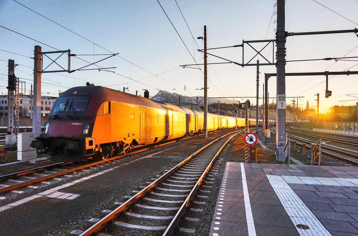 Angestrahlt von der Abendsonne, fahren railjet 565 (Innsbruck Hbf - Flughafen Wien (VIE)) und railjet 165 (Zürich HB - Budapest Keleti), in den Salzburger Hbf ein.
Aufgenommen am 29.12.2016.
