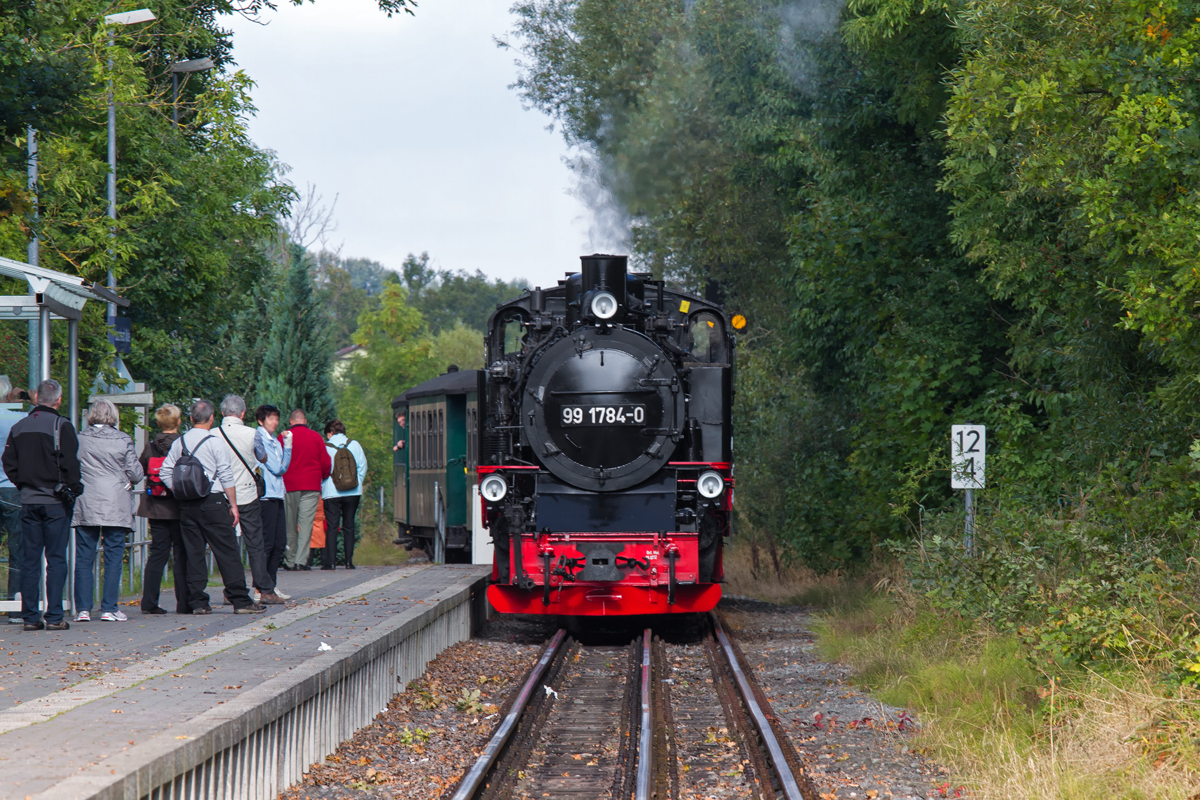 Ankunft des Rasenden Rolands am Haltepunkt Lauterbach Mole. Zusehen auch das Dreischienengleis mit 750 und 1435 mm, das von Putbus nach Lauterbach Mole führt. - 21.09.2013 - Aufgenommen vom Weg hinter dem Gleisabschluss.
