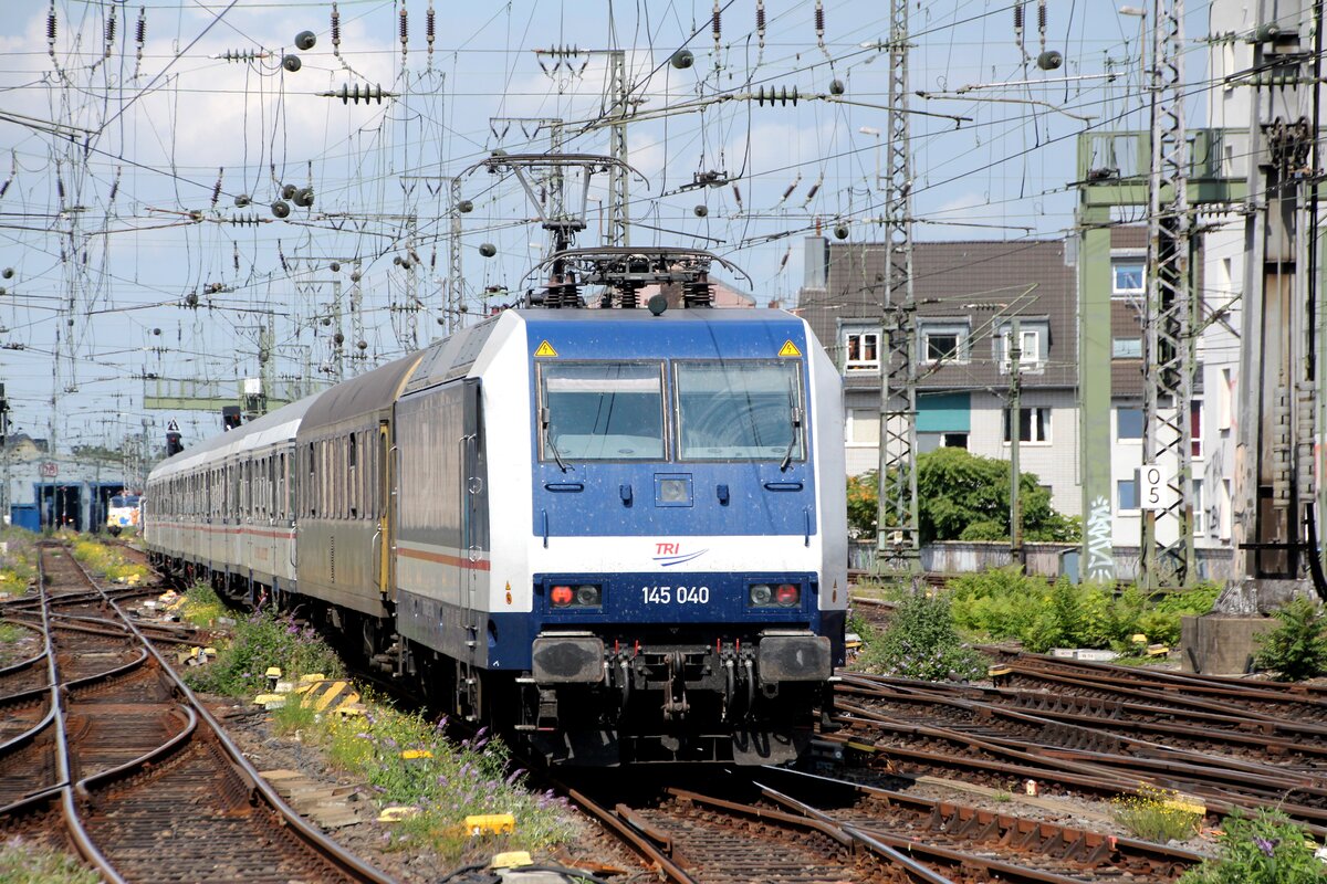 Anlässlich der Gamescom 2025 verstärkt TRI den RE1 zwischen Düsseldorf und Köln im Wendezugbetrieb. Am Donnerstag, dem 21.08.2025 war 145 040-2 nach dem Halt auf Gleis 5 des Kölner Hbf schiebend auf dem Weg zu einer kurzzeitigen Pause im Bbf am Hansaring, bevor es dann ziehend wieder in Richtung Düsseldorf Hbf gehen sollte. 
Im Hintergrund gerade noch erkennbar die für Rangierzwecke eingesetzte TRI Elefanten-Lok 110 469-4.