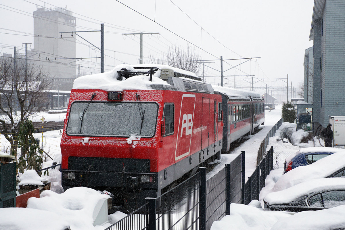 Appenzeller Bahnen/AB.
Auf dem letzten Platz gelandet in der Abstellanlage Gossau ist der einstige Stolz der AB.
Die Ge 4/4 1 wurde im Jahre 1994 in Betrieb genommen für die Führung der schweren Rollbockzüge. Nach der Einstellung des gesamten Güterverkehrs bei der AB im Jahre 2010 wurde sie sehr oft im Personenverkehr eingesetzt. Endgültig aus dem Betrieb verdrängt wurde sie 2018 durch die neuen ABe 4/12  Walzer  1001 - 1005 sowie die ABe 8/12  Tango  4001/4101 - 4011/4111.
Auch die neuen Gem 2/2 machen der Ge 4/4 1 zusätzlich die Existenzberechtigung schwer.
Das traurige Bild der einzigen Lokomotive der AB ist am 27. Januar 2021 in Gossau ab einer öffentlich zugänglichen Stelle entstanden. Einzige Möglichkeit für eine spezielle Winteraufnahme dieser Exotin.
Foto: Walter Ruetsch    