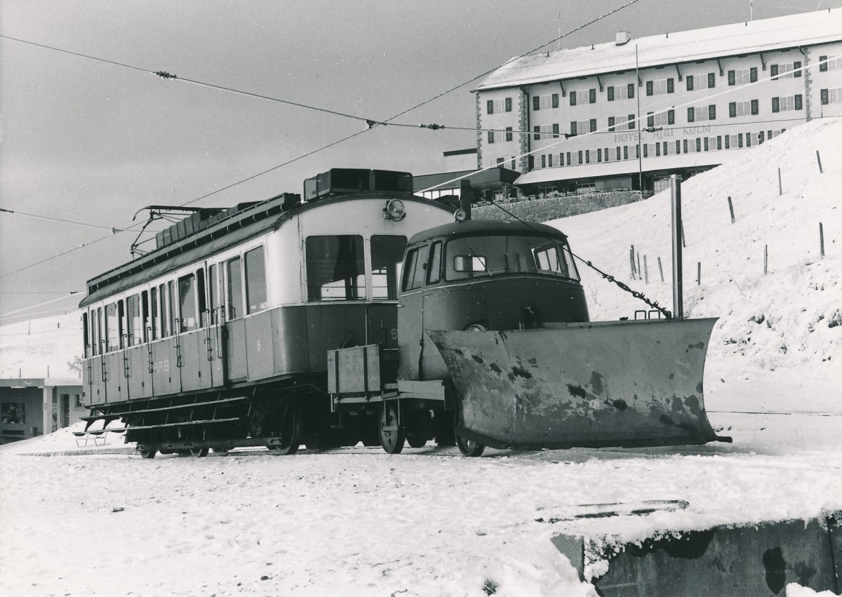 ARB: BDhe 2/3 6 (1911) noch im blauen Kleid mit Schneepflug in Rigi Kulm am 10. November 1985. Für das Führerhaus des Schneepfluges wurde die Kabine eines alten Mercedes Lieferwagen zweckentfremdet. Zu dieser Zeit befand sich der Triebwagen in einem sehr schlechten Zustand. Aus diesem Grunde war er nur noch selten auf der Strecke unterwegs. Auch eine Total-Revision war damals noch keine beschlossene Sache.
Foto: Walter Ruetsch 
