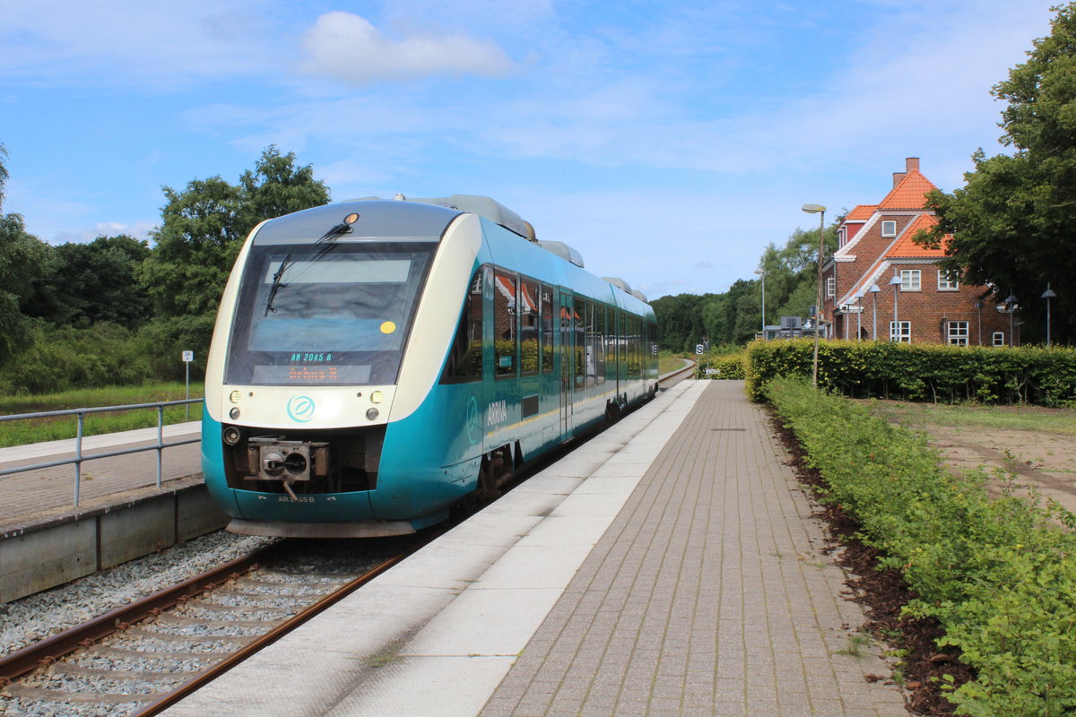 Arriva: Der LINT AR 2045 erreicht am 9. Juli 2020 den Bahnhof Rødkærsbro auf der Bahnstrecke Langå - Bjerringbro - Rødkærsbro - Viborg - Skive - Struer. - In den Jahren 1912 bis 1968 gab es eine Privatbahnverbindung (34,5 km) zwischen Silkeborg und Rødkærsbro über Kjellerup (Silkeborg - Kjellerup - Rødkærsbro - Jernbane (SKRJ)). - Die kleine Stadt Rødkærsbro hat 1729 Einwohner und liegt 16 km südöstlich von Viborg. - Einige kleine dänische Städte haben wie Rødkærsbro das Glück, an einer Bahnstrecke zu liegen. Viele Kleinstädte, die ihre Bahnverbindung, d.h. eine leistungsfähige öffentliche Verkehrsverbindung, verloren haben, haben einen - oft merkbaren - Rückgang erlebt. Dort ist oft die Entwicklung stagniert, viele Einwohner sind weggezogen und das Wirtschafts- und Geschäftsleben ist ausgestorben. 