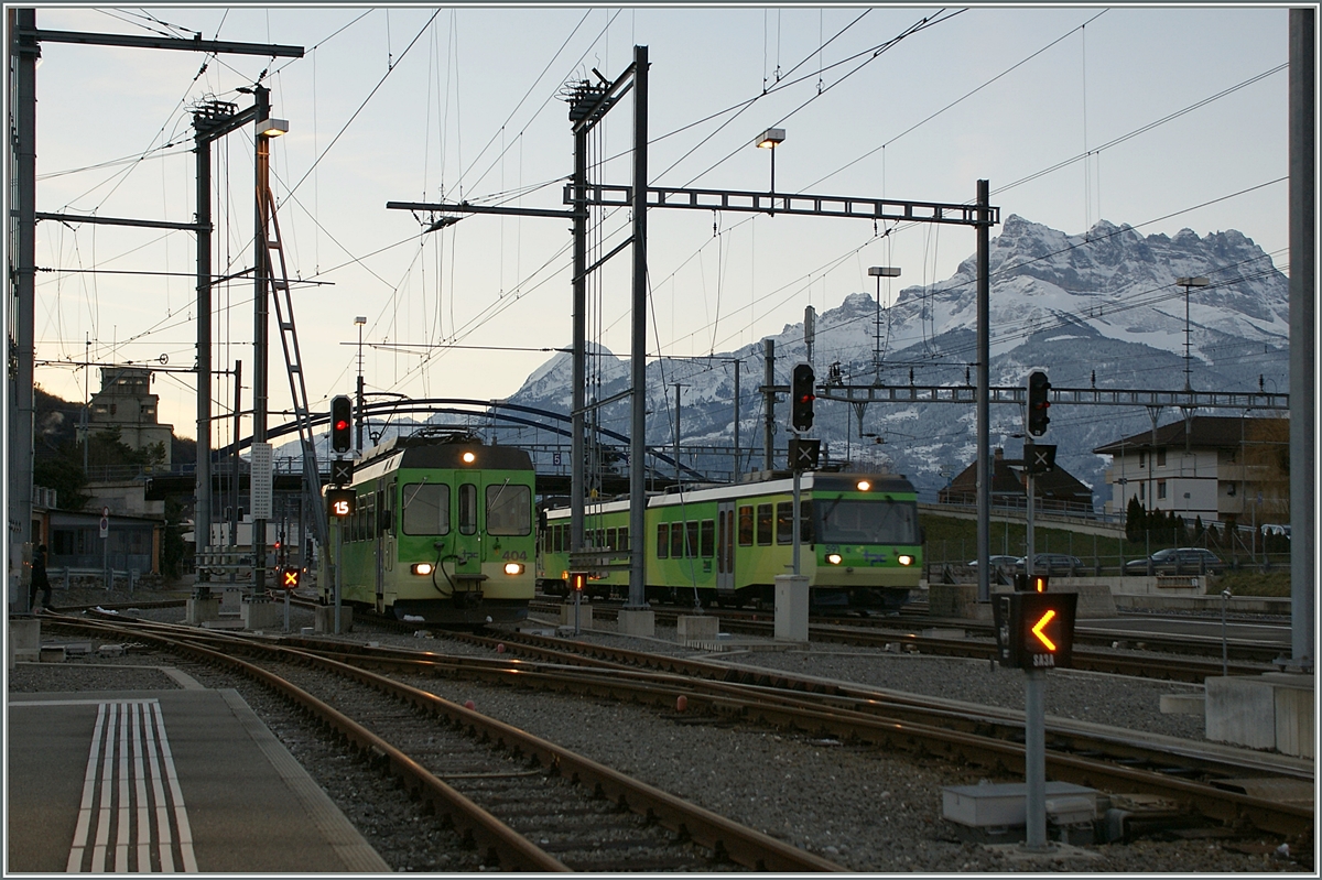 ASD BDe 4/4 404 und AOMC Beh 4/8 591 im noch schattigen Bahnhof von Aigle vor dem Hintergrund des Dents de Midi. 

25. Jan. 2014