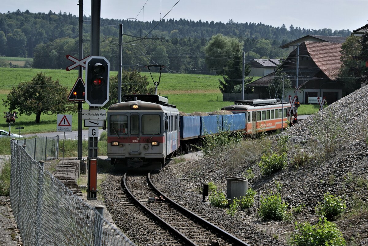 ASM BTI Aare Seeland mobil AG Biel-Täuffelen-Ins-Bahn: Be 4/4 304 + Fa 576 + Fa 571 + Fa 572 + Be 4/4 302, Zug 8281 Finsterhennen-Sutz auf dem Anschlussgleis Hurni, Sutz, 17. August 2021. Das Ent- und Beladen (innert rund 20 Minuten) liess sich in Sutz als  Zaungast  mitverfolgen.