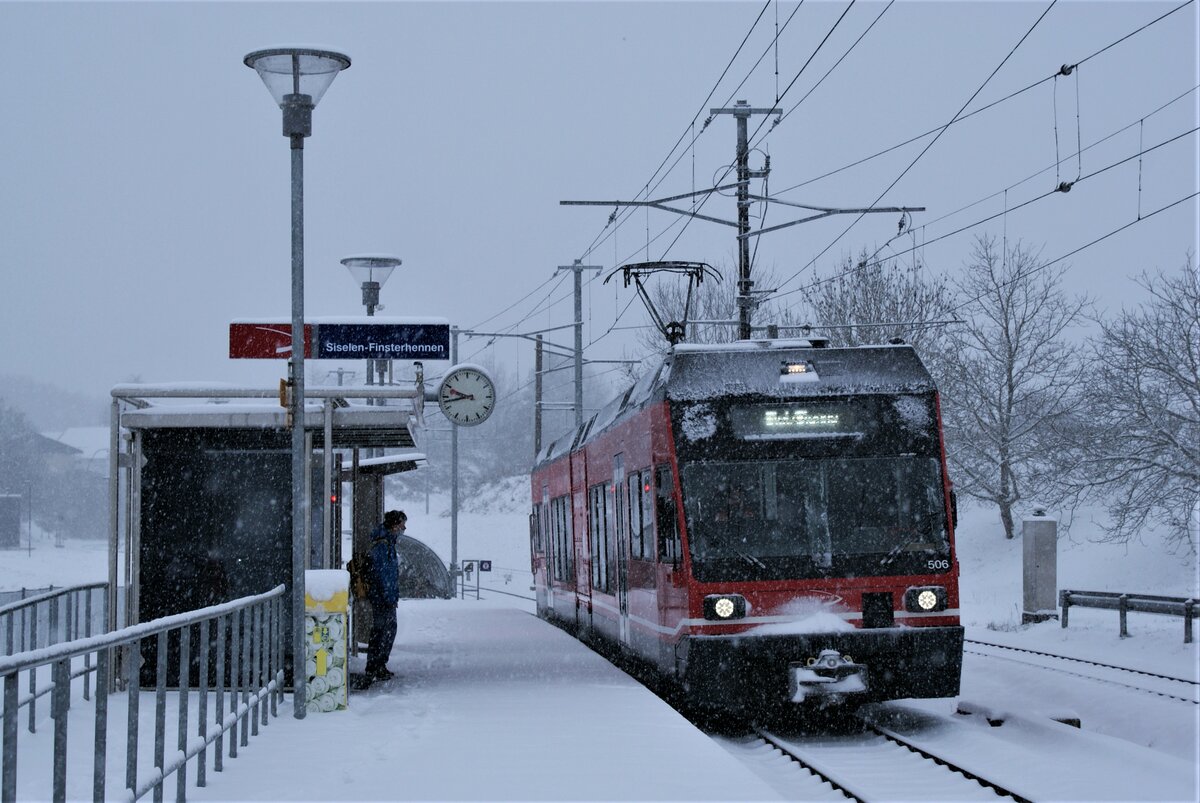 ASM BTI Aare Seeland mobil AG Biel-Täuffelen-Ins-Bahn: Be 2/6 506, Zug 7045 Ins-Biel, Haltestelle Siselen-Finsterhennen, 10. Dezember 2021. Das rechte Gleis führt nach hinten und in einer engen Kurve hinein in die Grube  Uf der Höchi  Finsterhennen. Im Rücken des Fotografen befinden sich die Dienststation Siselen Ausweiche und die Abstellanlage Siselen.