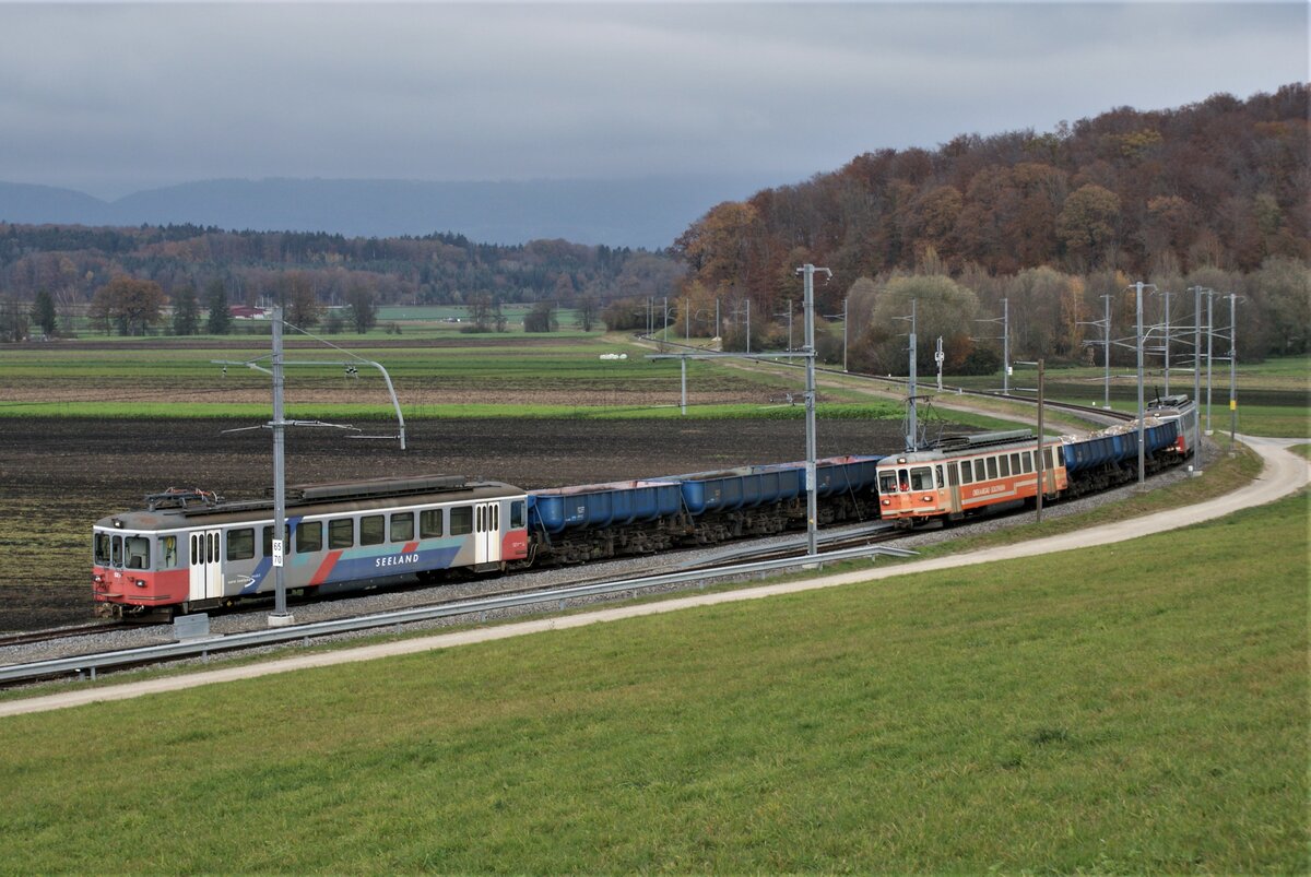 ASM BTI Aare Seeland mobil AG Biel-Täuffelen-Ins-Bahn: Be 4/4 302 + Fa 572 + Fa 571 + Fa 576 + Be 4/4 304, Zug 8250 Sutz-Finsterhennen, Siselen, 9. November 2021. Dieses Bild vereint fast das gesamte vorhandene Kieszugrollmaterial: Auf dem Abstellgleis stehen Be 4/4 525 + Fa 573 + Fa 575 + Fa 574; es fehlt der Be 4/4 523, der in der umzäunten Abstellanlage in Biel steht. Die BTI-eigenen Be 4/4 523 und 525 (ex SZB) sind um ein Fenster länger als die Be 4/4 302 und 304 aus dem Bestand von Langenthal.