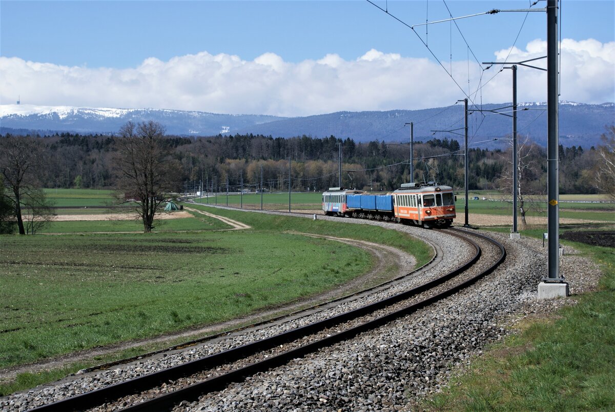 ASM BTI Aare Seeland mobil AG Biel-Täuffelen-Ins-Bahn: Be 4/4 302 + Fa 572 + Fa 571 + Fa 576 + Be 4/4 304, Zug 8286 Sutz-Finsterhennen, Lüscherzmoos, 12. April 2021. Im Hintergrund ist die Haltestelle Lüscherz zu erkennen. Den Horizont begrenzt die Jurakette mit dem schneebedeckten Chasseral (mit Fernmeldeanlage) und dem Mont Sujet (Spitzberg).