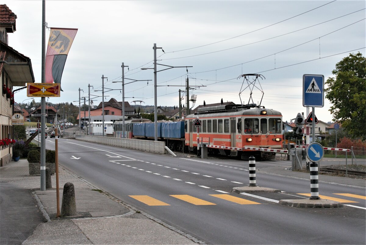 ASM BTI Aare Seeland mobil AG Biel-Täuffelen-Ins-Bahn: Be 4/4 302 + Fa 572 + Fa 571 + Fa 576 + Be 4/4 304, Zug 8286 Sutz-Finsterhennen, Hagneck, 20. Oktober 2021. Strassen- und Bahnbrücke über den Hagneck-Kanal stehen unmittelbar nebeneinander. An der Bahnbrücke hängt zudem ein Fussgängersteg (vom Zug weitgehend verdeckt). 