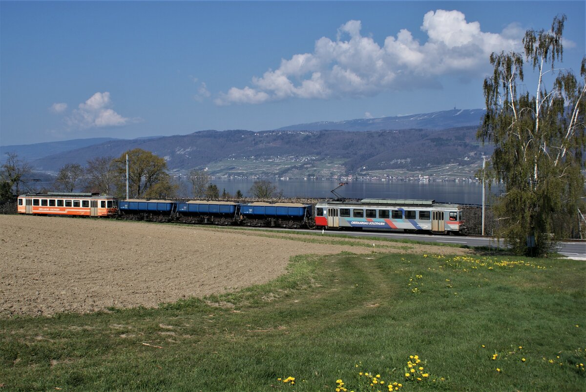 ASM BTI Aare Seeland mobil AG Biel-Täuffelen-Ins-Bahn: Be 4/4 304 + Fa 576 + Fa 571 + Fa 572 + Be 4/4 302, Zug 8245 Finsterhennen-Sutz, Mörigen, 22. April 2021. Am gegenüberliegenden Ufer des Bielersees liegen Ligerz mit seiner Kirche in den Rebbergen und Twann, dazwischen die Twannbachschlucht, unterhalb des Waldes Schernelz, darüber Prêles/Prägelz (Bergstation der Ligerz-Tessenberg-Bahn, auch ein ASM-Betrieb). In der Ferne ist der Chasseral mit letzten Schneeresten erkennbar.