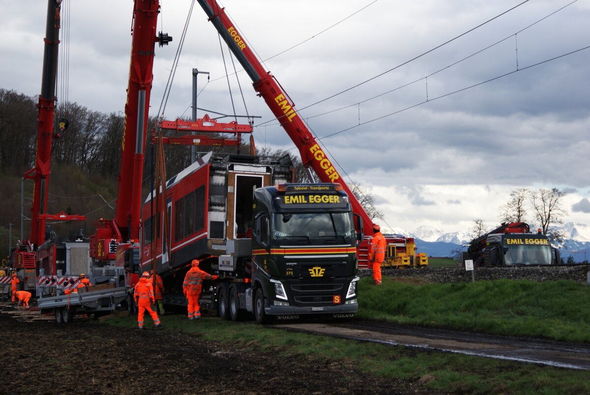 ASm BTI Aare Seeland mobil AG Biel-Täuffelen-Ins-Bahn: Verlad des abgetrennten Teils 506.2 von GTW 506, Lüscherzmoos, 1. April 2023 (gegen 17.20 Uhr). Durch Schwenken des Kranes mit der Last im Halbkreis ist der Wagenteil gedreht.   