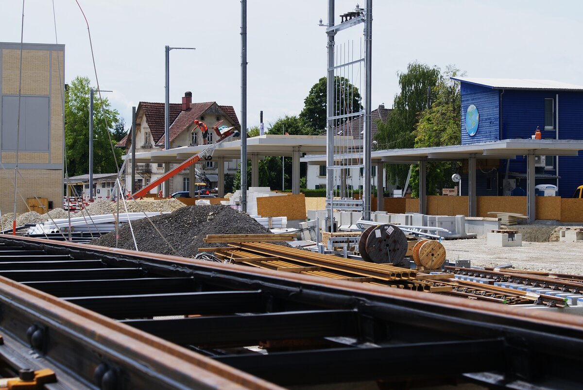 ASm BTI Aare Seeland mobil AG Biel-Täuffelen-Ins-Bahn: Neubau der Bahnstation, Nidau, 21. Juli 2023. Im Bildvordergrund lagert das in der Station und im Bereich der Hauptstrasse zu verbauende Gleismaterial. Auf dem abgebrochenen Gleisabschnitt in der Hauptstrasse waren die Rillenschienen auf Holzschwellen montiert. 