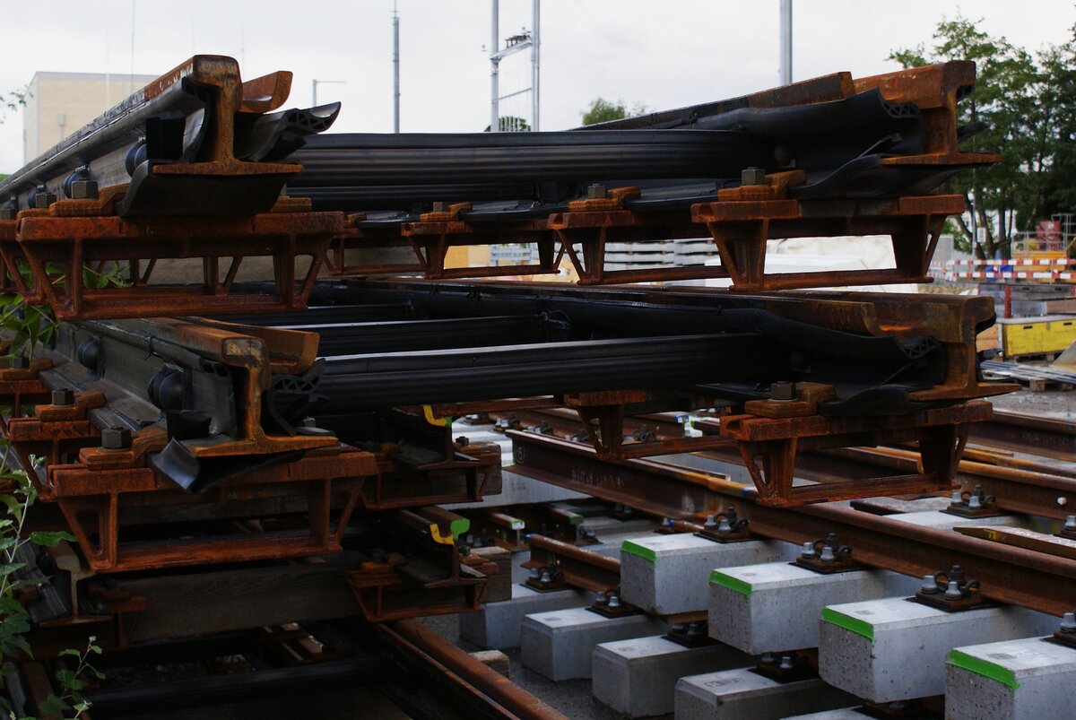 ASm BTI Aare Seeland mobil AG Biel-Täuffelen-Ins-Bahn: Detailaufnahme von Gleisjochen, vorbereitet zum Einbau im Kreisel, Neubau des Niveauüberganges Hauptstrasse, Nidau, 6. August 2023. Das auf Betonschwellen montierte obere Gleiselement besitzt angeschweisste Rillenschienen und wird an das  Tramgleis  anschliessen.