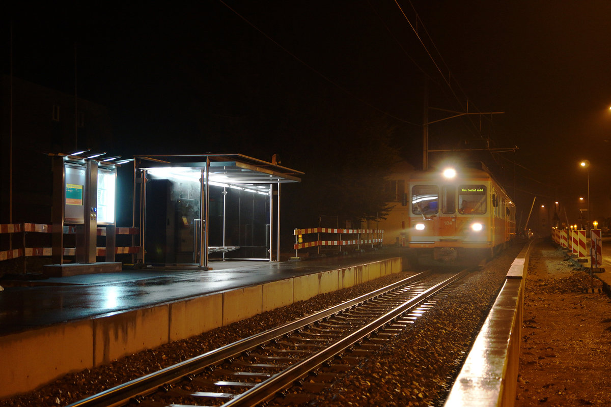 ASm: Mit dem Eintreffen des Regio 7736 in Solothurn HB um 20:44h wurde am 23.Oktober 2016 der Pendelverkehr Solothurn HB-Flumenthal mit dem Be 4/4 104 beendet. Anschliessend wurden mit den beiden alten Triebwagen die Testfahrten  zwischen der Station Bei den Weihern und dem Bahnhof Wiedlisbach durchgeführt. Um 22:40h befuhr der erste Testzug die neue Streckenführung Flumenthal. Auf dem einen Bild sichtbar ist die neue Barrierenanlage, das neue Stationsgebäude sowie die von der Strasse abgetrennte Streckenführung. Das alte Bahnhofsgebäude Flumenthal wurde abgerissen. Die Aufnahmen entstanden ohne Blitz aus freier Hand.
Der Bahnersatzbus Solothurn-Wiedlisbach mit Halt auf Verlangen auf allen Stationen verkehrte noch bis Betriebsschluss.
Foto: Walter Ruetsch