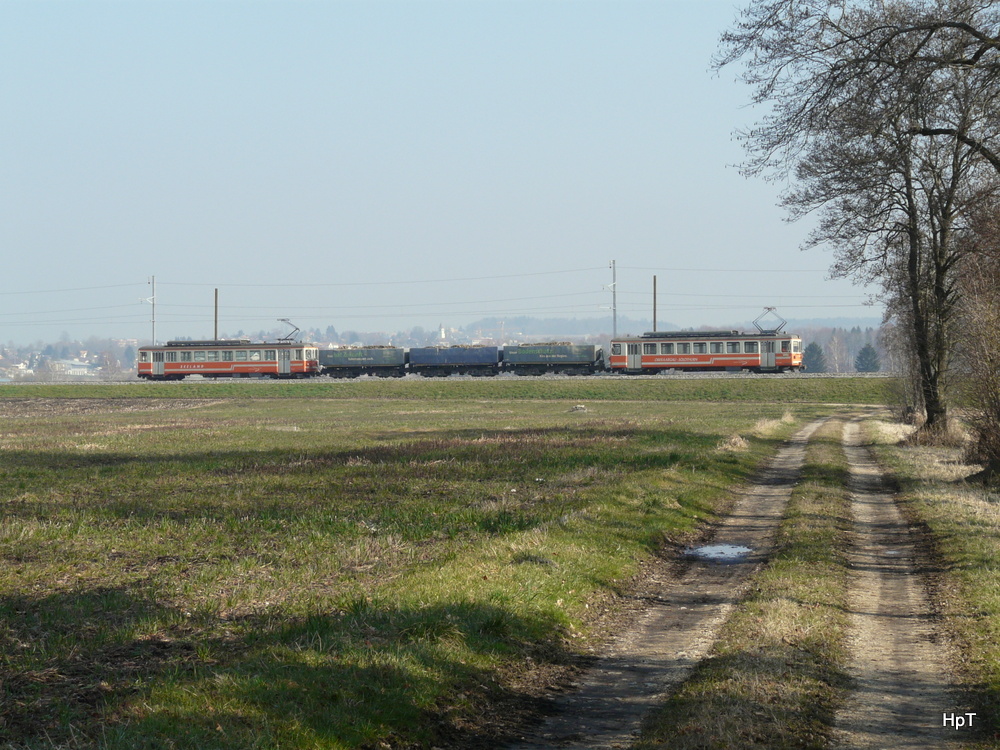 asm Seeland - Kieszug mit Be 4/4 302 mit 3 Kieswagen und am Schluss der Be 4/4 523 unterwegs zwischen Lüscherz und Siselen am 07.03.2014