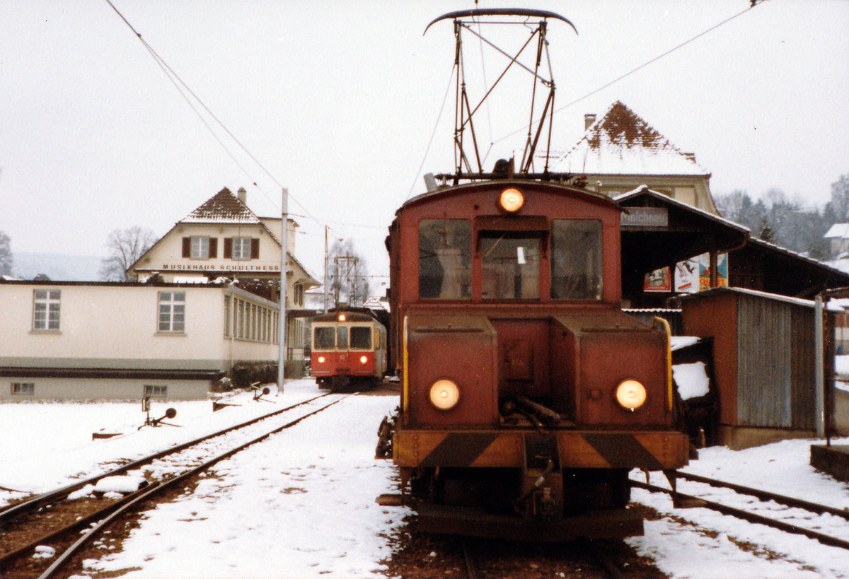 ASM/OJB/LMB: EINST UND JETZT. Die LMB-Strecke Langenthal-Melchnau wurde im Jahre 1917 eröffnet. Im Jahre 1982 erfolgte die Umstellung des Personenverkehrs zwischen St. Urban und Melchnau auf Busbetrieb. Eine Verlängerung des Bahnbetriebes bis St. Urban Ziegelei erfolgte 1989. Für den Güterverkehr (Normalspurwagen auf Rollböcken) sowie Personen-Extrazüge konnte die Strecke nach Melchnau weiterhin betrieben werden. Die Aufhebung der Konzession für den Streckenabschnitt St. Urban Ziegelei-Melchnau Fabrik erfolgte im Jahre 2012 sowie der Abbau von Geleisen und Fahrleitung im Winter 2015.
Im März 1982 kam es auf der Endstation Melchnau noch zu Zusammentreffen von Personen- und Güterzügen. OJB Be 4/4 82 und die Ge 4/4 56 (ehemals LMB) mit dem Güterzug kurz vor der Abfahrt nach Langenthal.
Foto: Walter Ruetsch